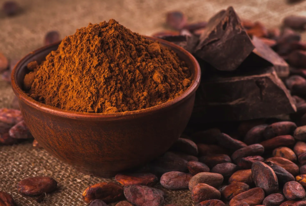 Какао-порошок в коричневой миске и какао-бобы