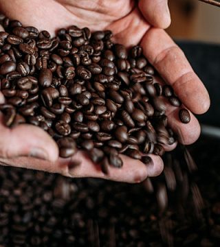 Жареные зерна кофе в ладонях