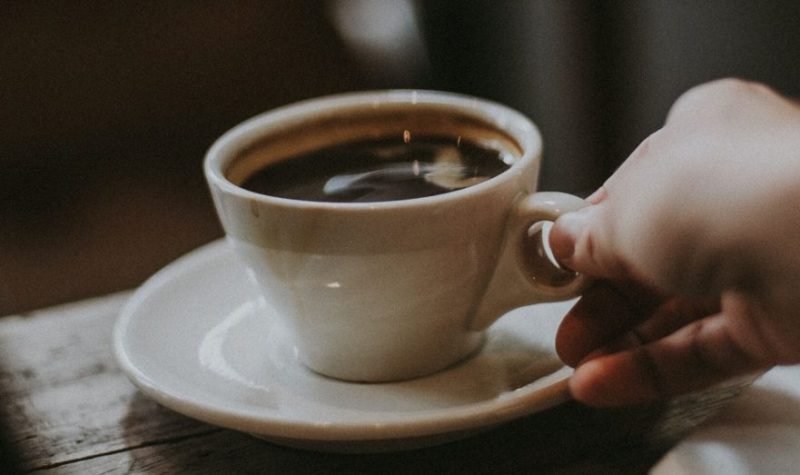 Чашка с кофе и рука